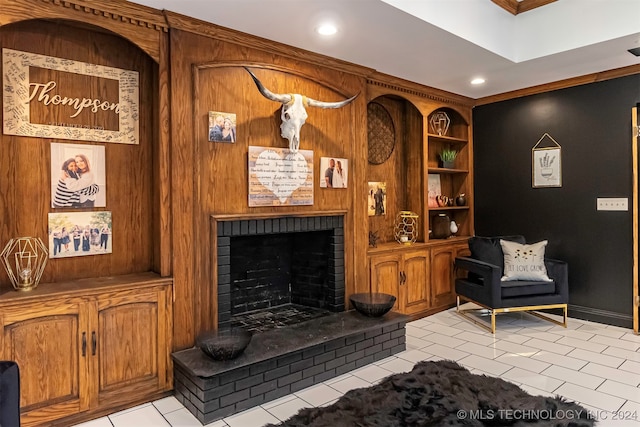 living area featuring light tile patterned flooring, crown molding, a fireplace, and wooden walls