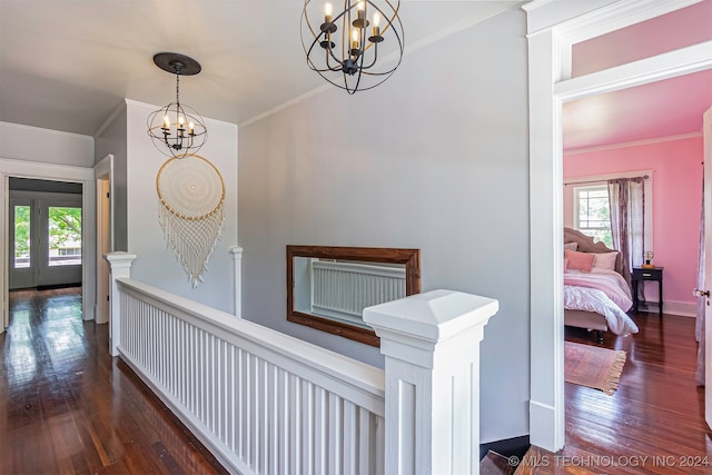 hallway featuring ornamental molding, a chandelier, and dark hardwood / wood-style flooring