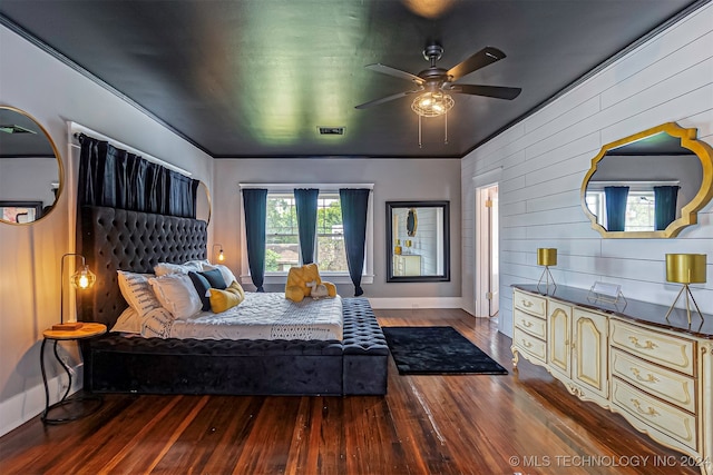 bedroom featuring wood walls, ornamental molding, hardwood / wood-style flooring, and ceiling fan