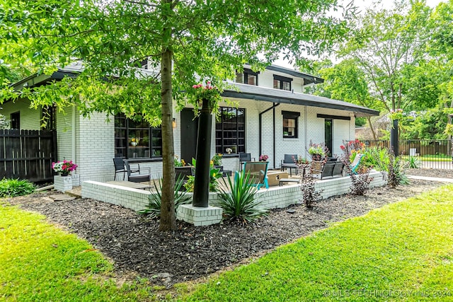 rear view of house featuring a yard