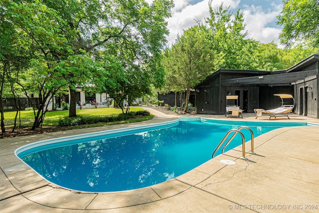 view of pool featuring a lawn and a patio