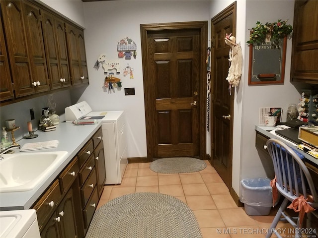 laundry room featuring light tile patterned flooring, washing machine and dryer, cabinets, and sink