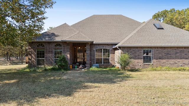 rear view of house featuring a yard