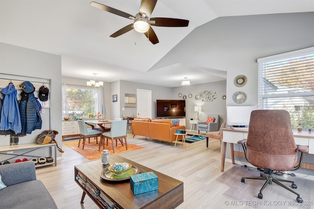 living room featuring ceiling fan with notable chandelier, light hardwood / wood-style floors, and vaulted ceiling