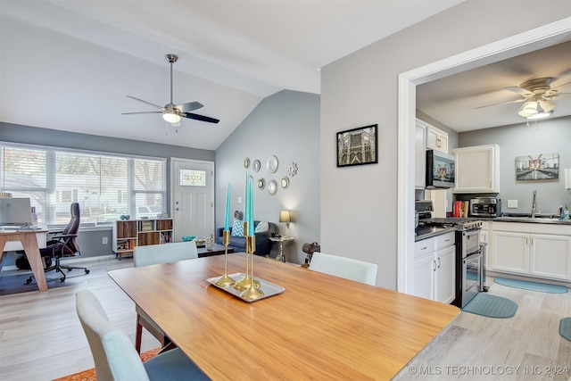 dining space with lofted ceiling, ceiling fan, light wood-type flooring, and sink