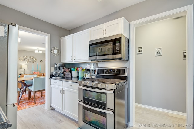 kitchen featuring white cabinets, light wood-type flooring, and appliances with stainless steel finishes