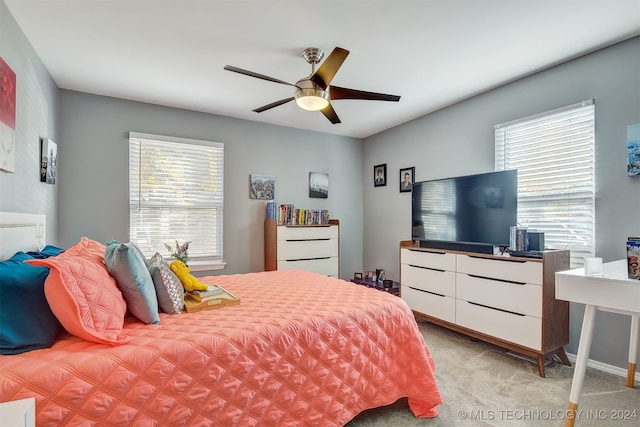 bedroom with light carpet, multiple windows, and ceiling fan