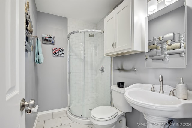 bathroom with tile patterned floors, sink, a shower with shower door, and toilet