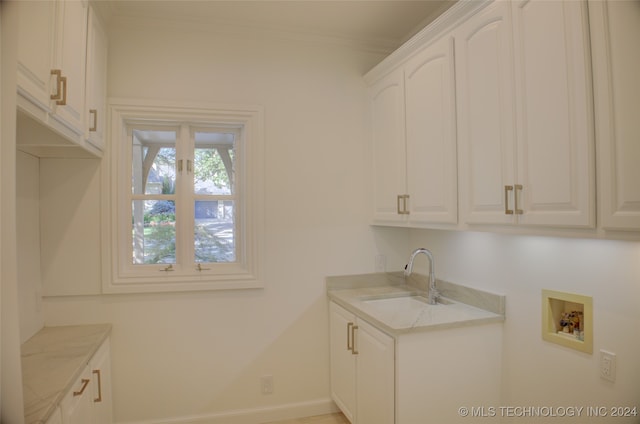 laundry room with cabinets, ornamental molding, sink, and washer hookup