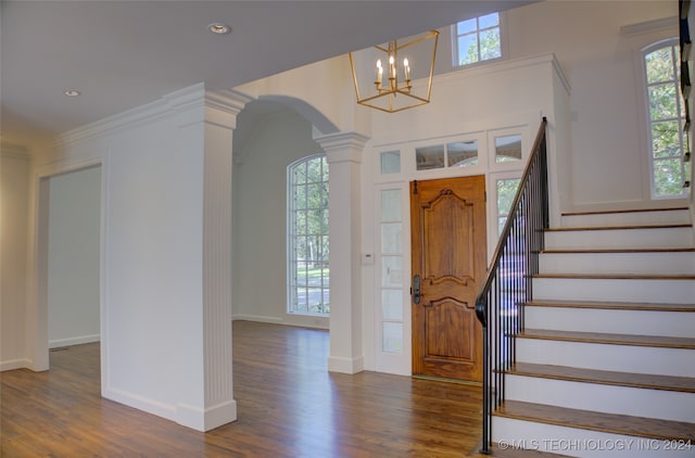 foyer with ornate columns, ornamental molding, and dark hardwood / wood-style floors