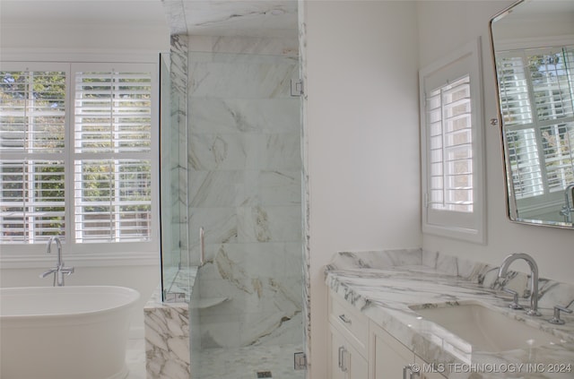 bathroom featuring vanity, separate shower and tub, and plenty of natural light