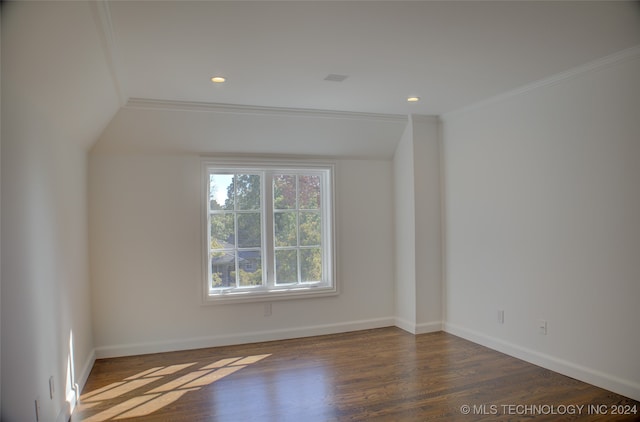 empty room with ornamental molding, vaulted ceiling, and dark hardwood / wood-style floors