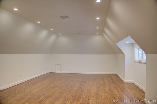 additional living space featuring lofted ceiling and hardwood / wood-style floors