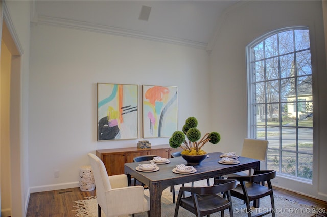 dining area featuring crown molding, vaulted ceiling, and hardwood / wood-style floors