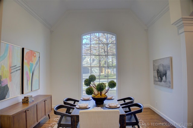 dining room with ornamental molding, vaulted ceiling, and light hardwood / wood-style floors