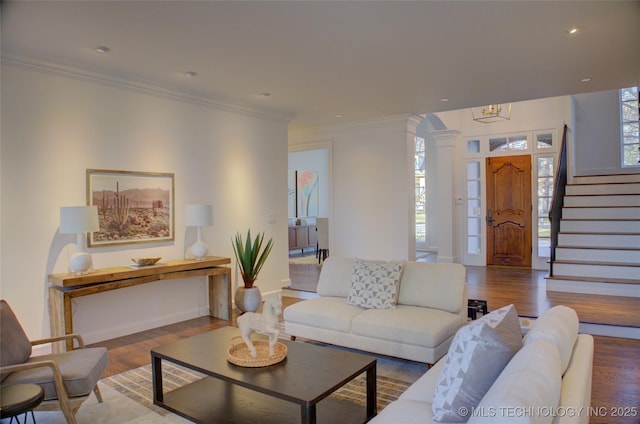 living room featuring crown molding, hardwood / wood-style flooring, and ornate columns