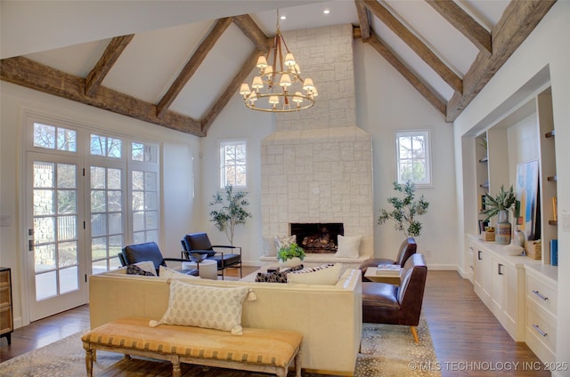 living room with hardwood / wood-style flooring, beam ceiling, high vaulted ceiling, a fireplace, and a chandelier