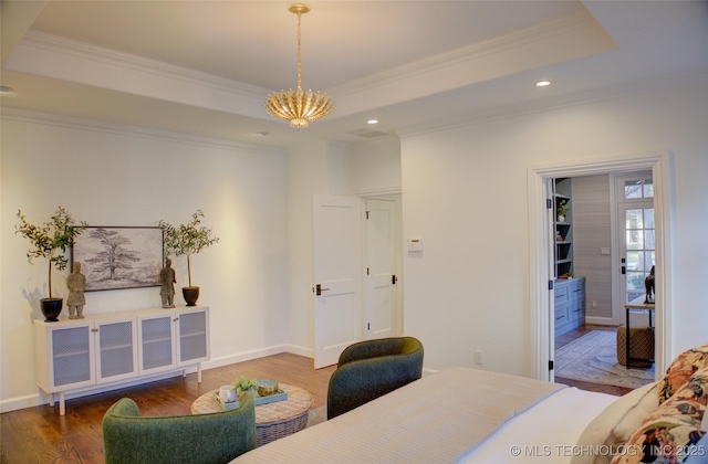 bedroom with a tray ceiling, ornamental molding, and hardwood / wood-style flooring