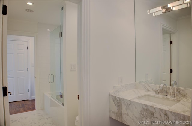 full bathroom featuring toilet, vanity, and shower / bath combination with glass door