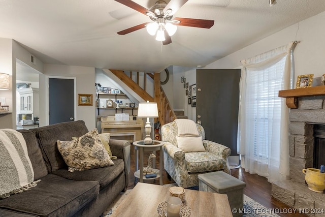 living room featuring a fireplace, ceiling fan, wood-type flooring, and a textured ceiling