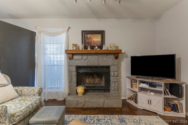 living room featuring a fireplace, dark hardwood / wood-style floors, and a textured ceiling