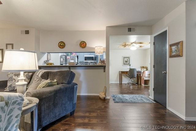 living room featuring ceiling fan and dark hardwood / wood-style floors