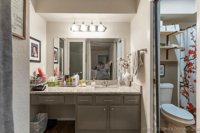 bathroom featuring wood-type flooring, vanity, and toilet