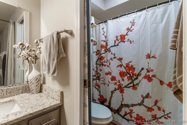 bathroom featuring a shower with shower curtain, vanity, and toilet