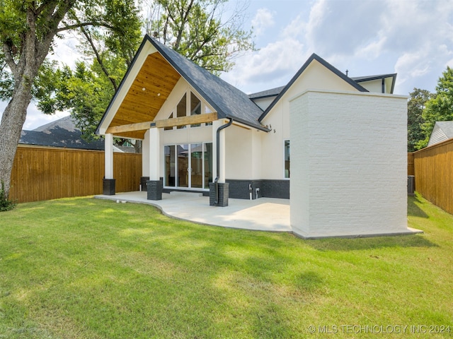 rear view of house featuring a mountain view, a yard, and a patio