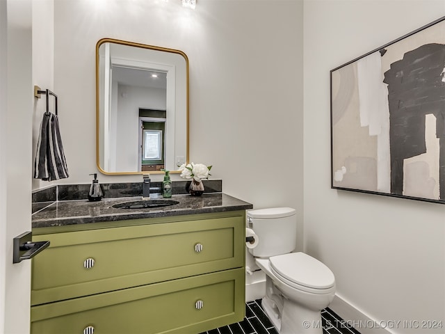 bathroom with tile patterned flooring, vanity, and toilet