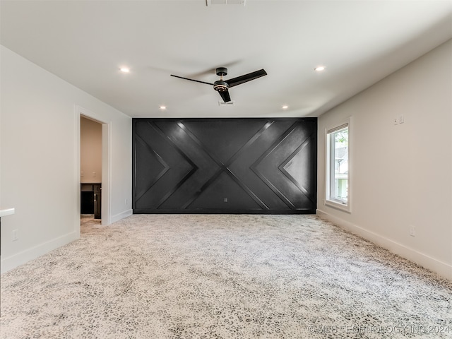 spare room featuring light colored carpet and ceiling fan