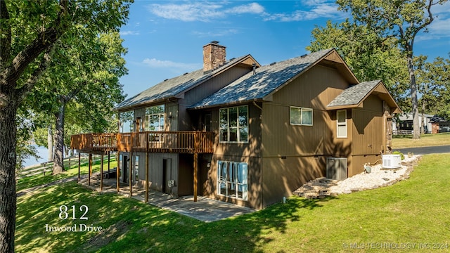 rear view of house with a deck and a lawn