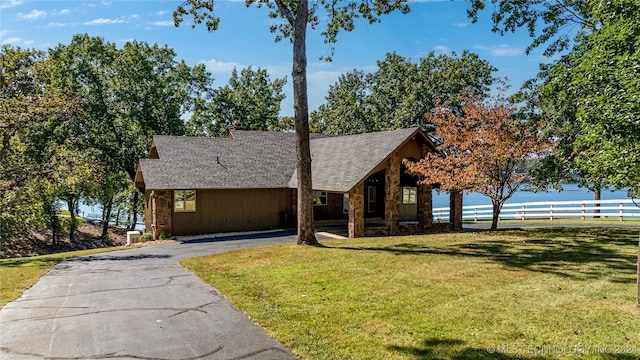 view of front of home with a water view, a carport, and a front yard