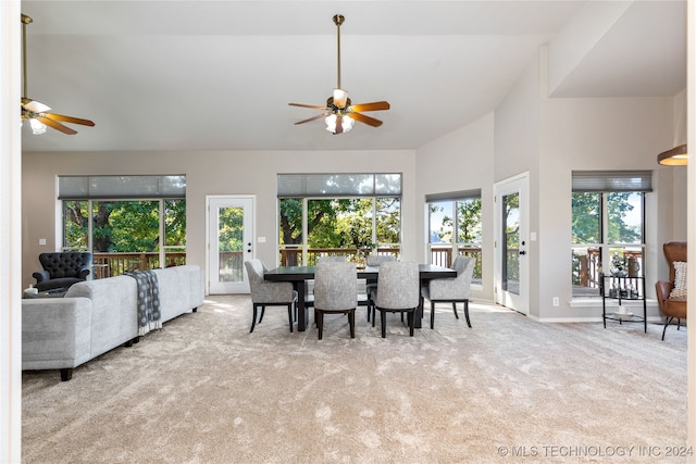 dining space with light carpet, high vaulted ceiling, and ceiling fan