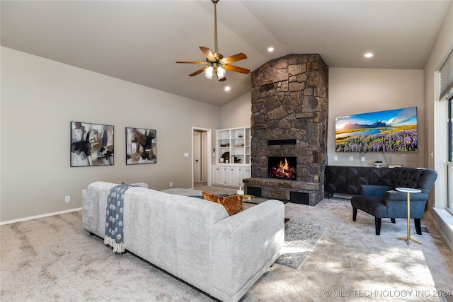 carpeted living room with a stone fireplace, high vaulted ceiling, and ceiling fan