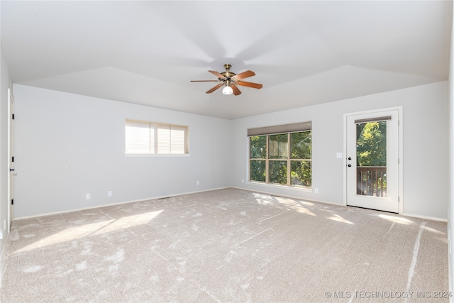 carpeted empty room with ceiling fan, plenty of natural light, and vaulted ceiling