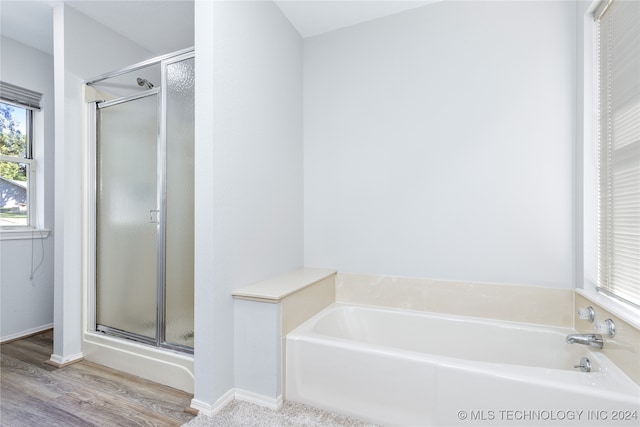 bathroom with independent shower and bath and hardwood / wood-style flooring