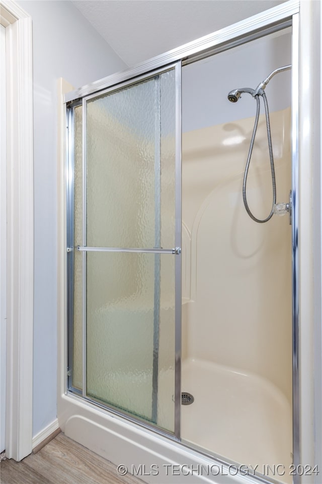 bathroom featuring a shower with door and hardwood / wood-style flooring