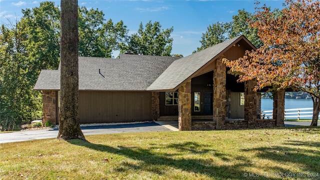 view of front of property featuring a front lawn and a water view