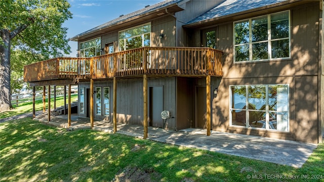 rear view of property with a deck and a lawn