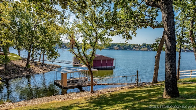 view of dock with a water view and a lawn