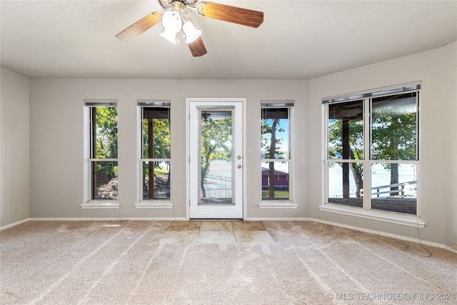 carpeted spare room featuring ceiling fan