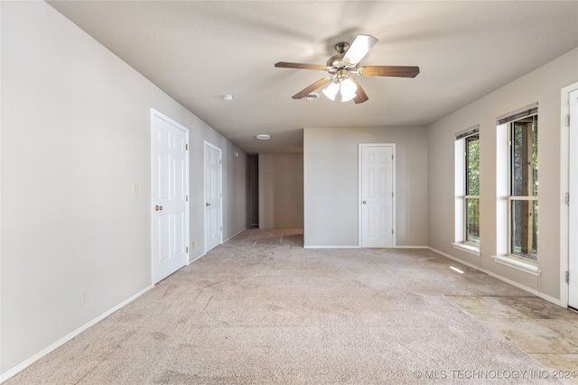 carpeted spare room with ceiling fan