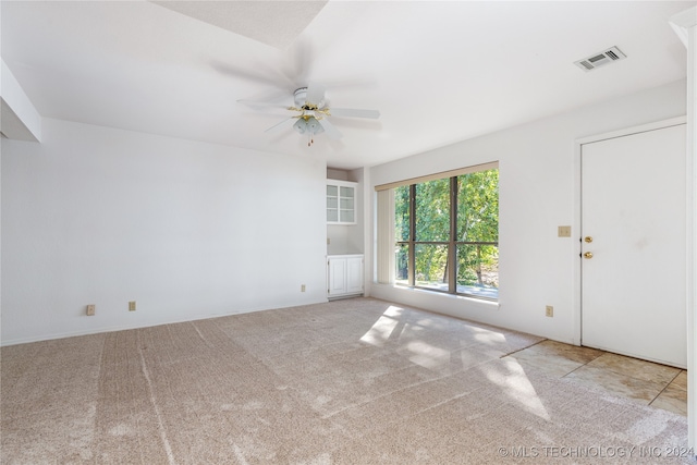 carpeted spare room with ceiling fan