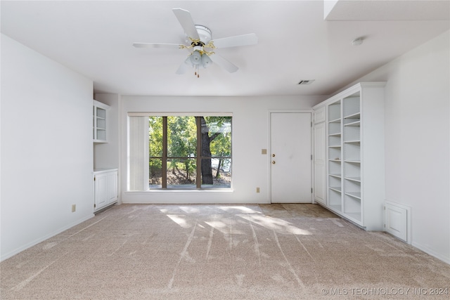 interior space with light carpet and ceiling fan