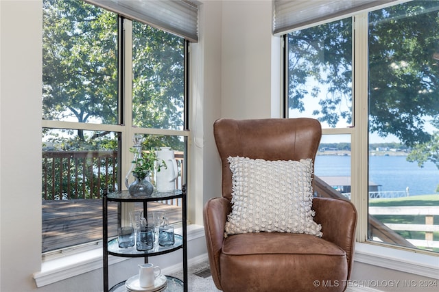 living area featuring expansive windows, a water view, and a wealth of natural light