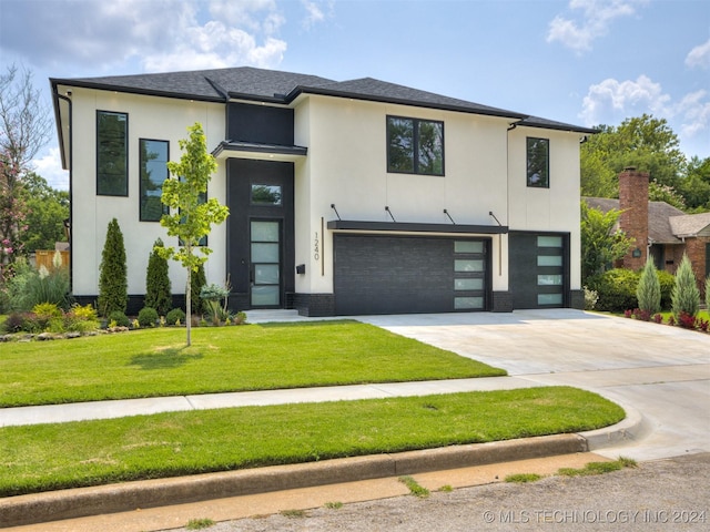 view of front of home with a front yard and a garage