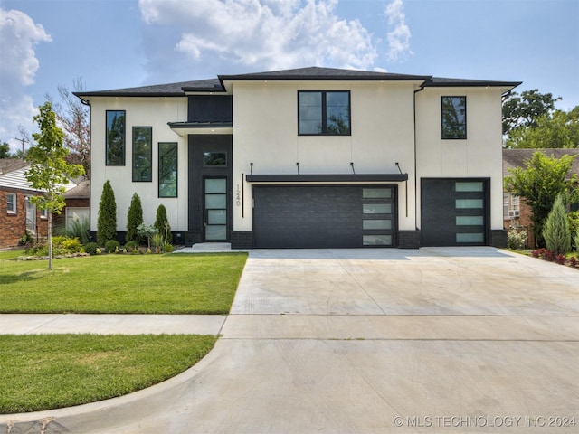 view of front of property with a garage and a front lawn