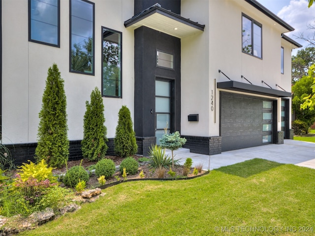 view of exterior entry with a yard and a garage