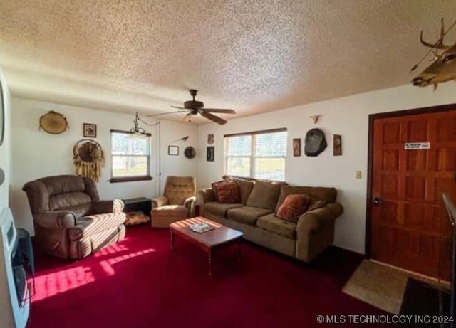 living room with ceiling fan, carpet floors, and a textured ceiling